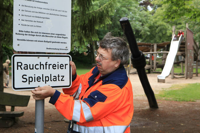 Mitarbeiter stellt Verkehrsschild auf 